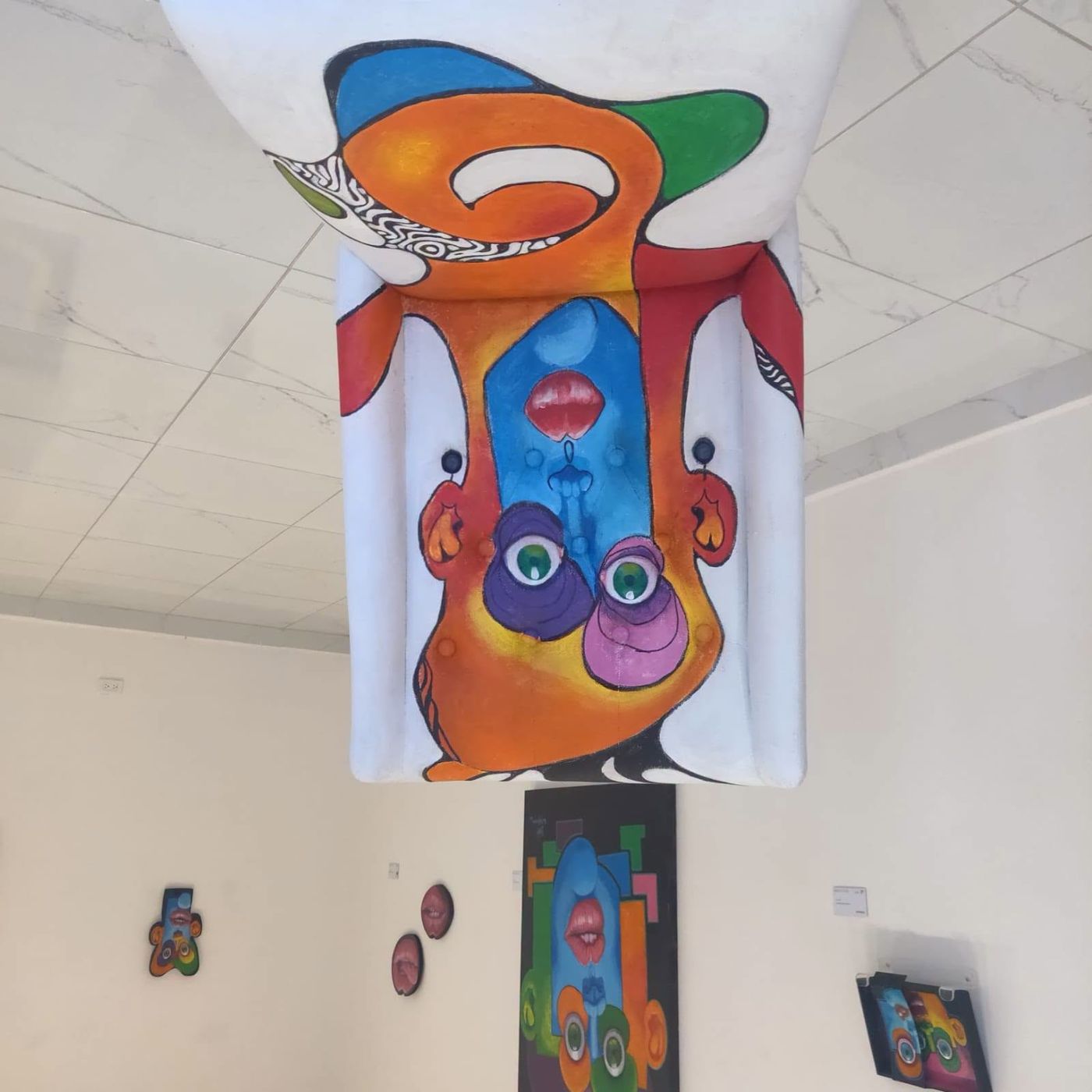 A painted Puzzle panel hanging from the ceiling in the gallery