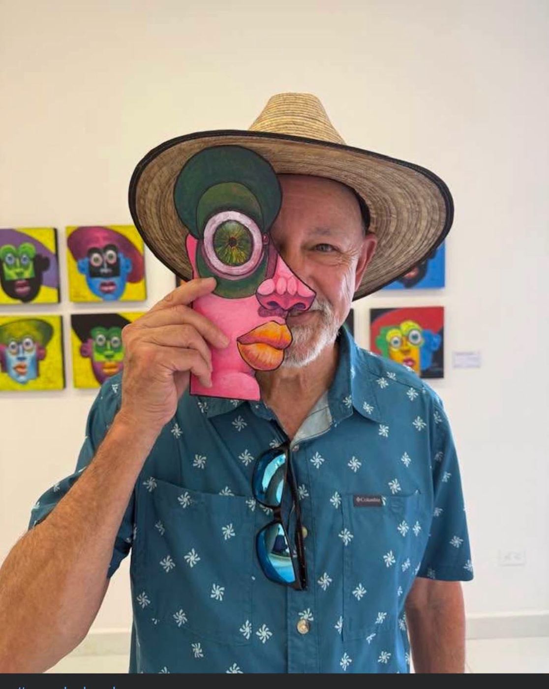 A visitor in a straw hat holding a Puzzle face piece