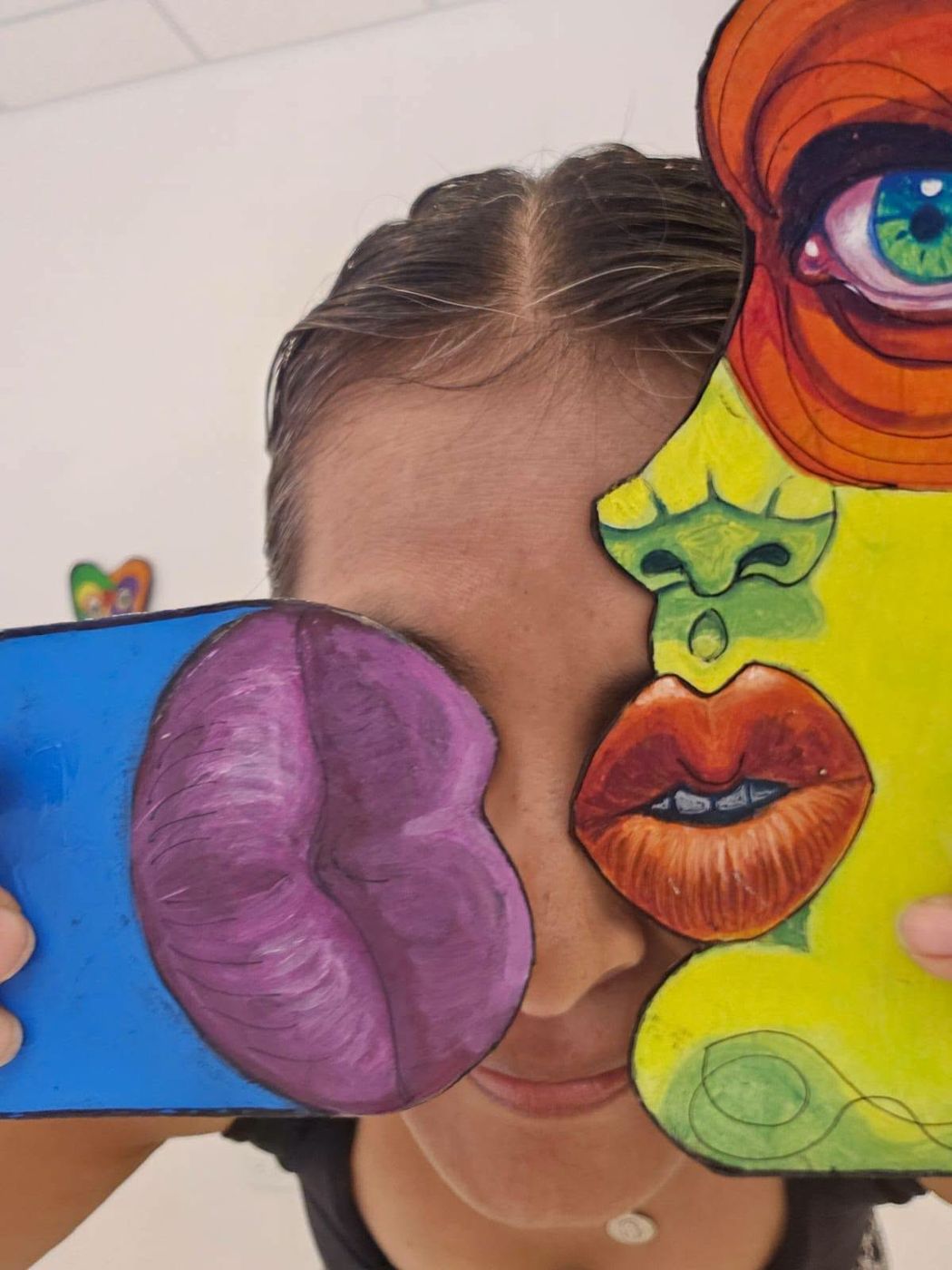A visitor holding Puzzle pieces over her eyes