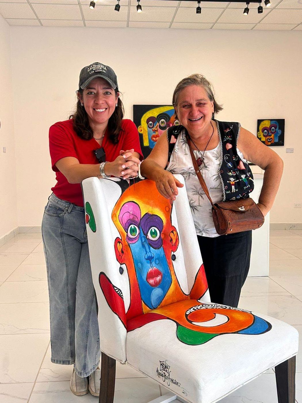 Rocío Hoffmann and a visitor with a painted Puzzle chair