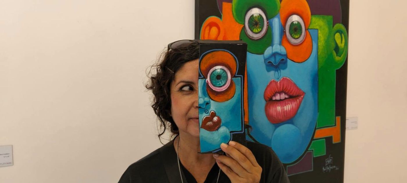 A visitor holding a Puzzle piece in front of a large painting
