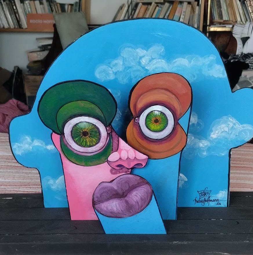 Puzzle art object on a stand: a sky-blue head with clouds and a pink face fitted into it