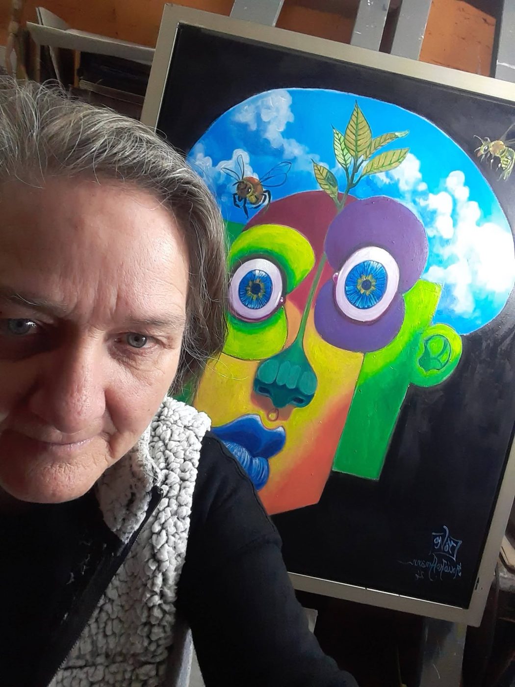 Rocío Hoffmann in her studio, next to one of her paintings on the easel