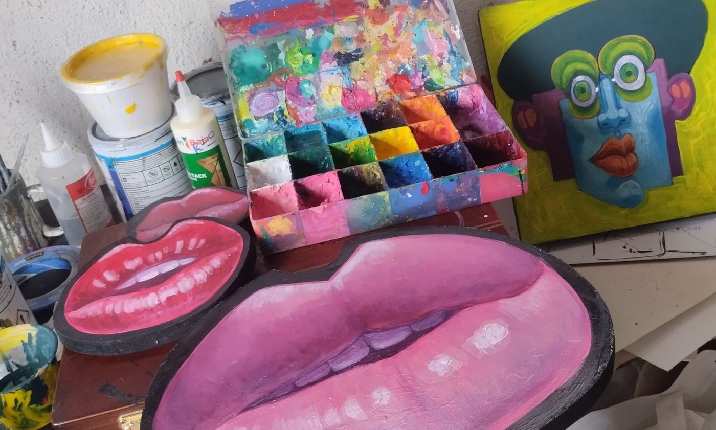 Painted lips pieces, a paint palette and a Puzzle painting on the studio table